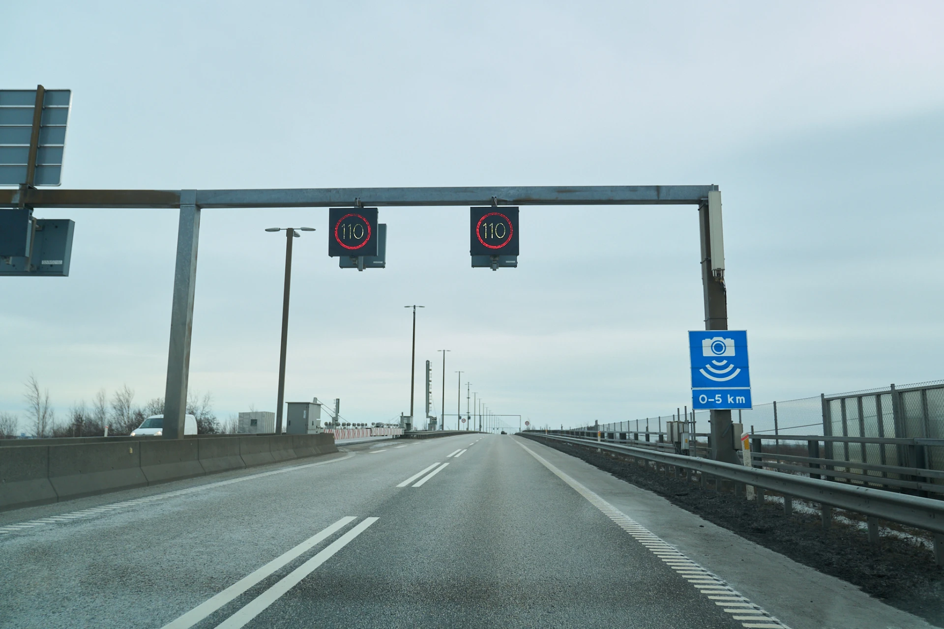 110 km/h speed limit signs and speed camera warning on the Øresund Bridge roadway, captured on February 6, 2026