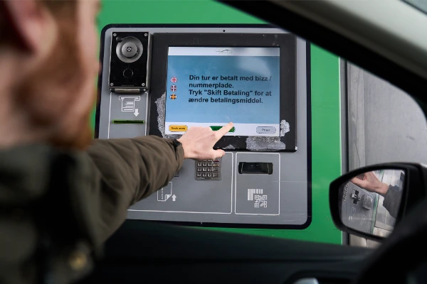 Testing the Øresund Bridge toll payment terminal from a car, showing the Danish-language screen with Bizz/numberplate payment confirmation and options to change payment method