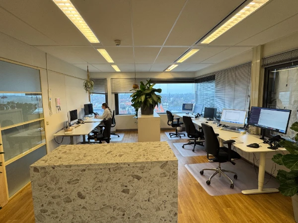 TheOresundBridge.com team office in Amersfoort with workstations, monitors and city view from the window